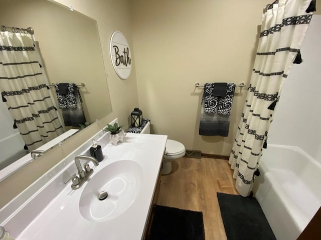 full bathroom with wood-type flooring, toilet, vanity, and shower / bath combination with curtain