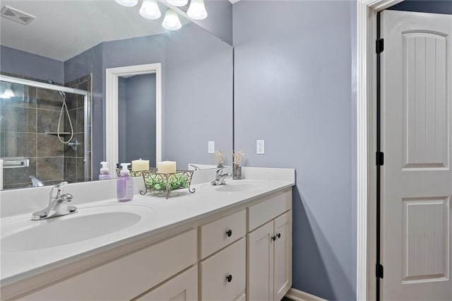 bathroom featuring a shower with door and vanity