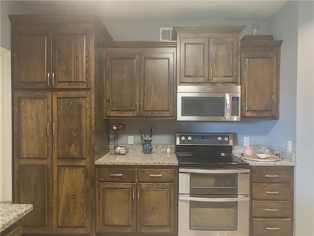 kitchen featuring light stone countertops and appliances with stainless steel finishes