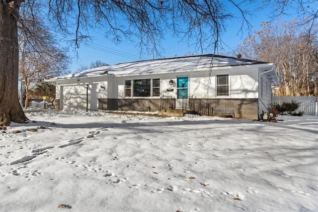 single story home with a garage, brick siding, and fence