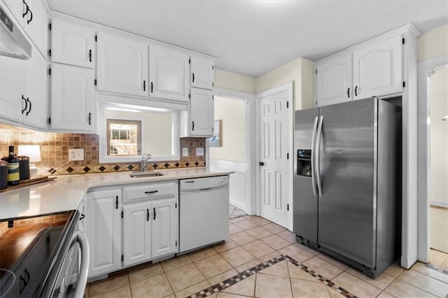 kitchen featuring light tile patterned floors, appliances with stainless steel finishes, white cabinets, and backsplash