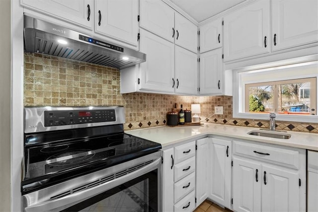 kitchen featuring stainless steel electric range oven, light countertops, a sink, and under cabinet range hood