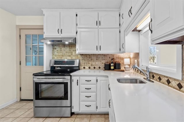 kitchen with white cabinets, light countertops, stainless steel range with electric cooktop, under cabinet range hood, and a sink