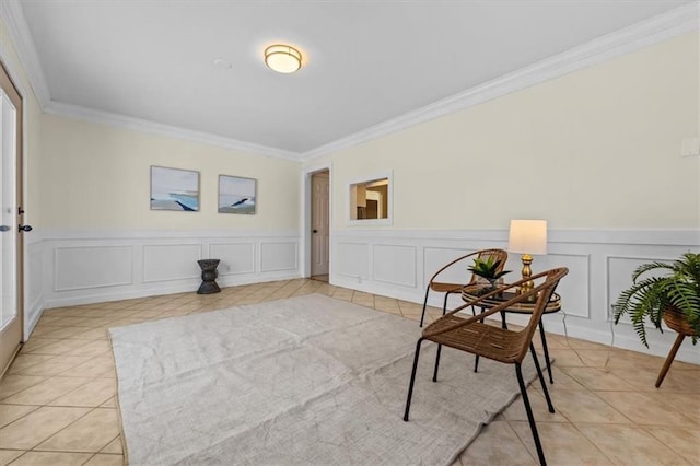 sitting room with crown molding, a decorative wall, and light tile patterned floors