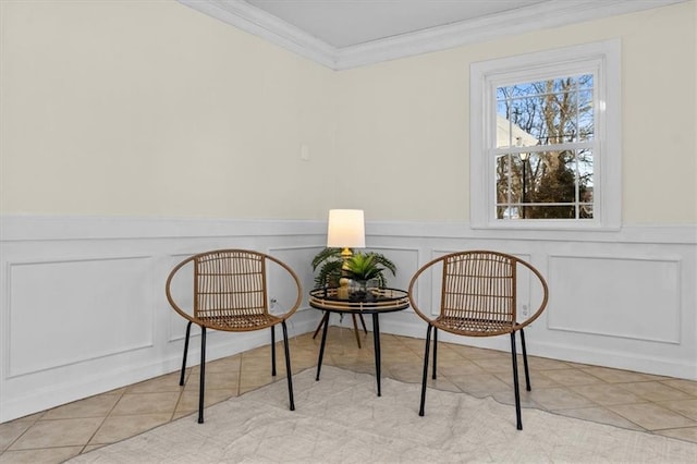 sitting room featuring a wainscoted wall, tile patterned flooring, and crown molding