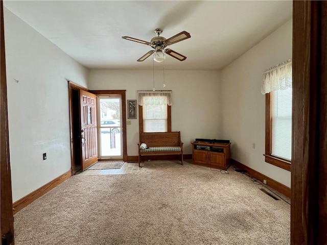 interior space featuring ceiling fan and light colored carpet