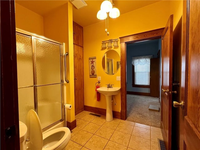 bathroom with tile patterned flooring, sink, and bath / shower combo with glass door