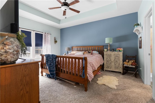 bedroom with carpet, ceiling fan, and a tray ceiling