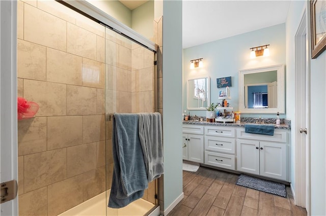 25215 W 141st Ter, Olathe, KS 66061 - bathroom featuring double vanity, a shower stall, and wood finished floors