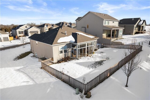 25215 W 141st Ter, Olathe, KS 66061 - snow covered property featuring a residential view, a fenced backyard, and a sunroom