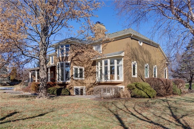 rear view of property featuring a lawn