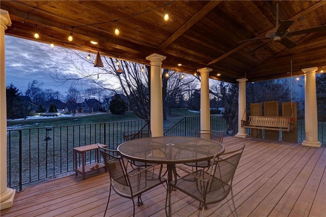 deck at dusk featuring ceiling fan