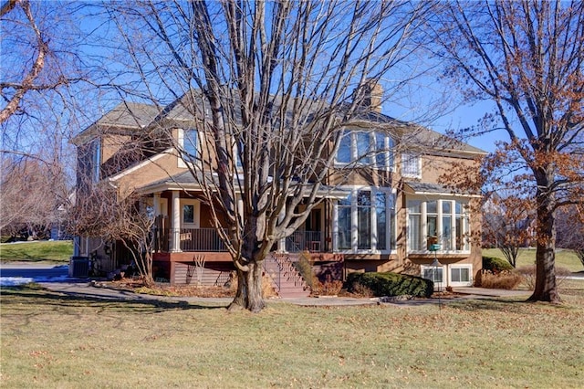 view of front of house featuring central AC unit, a front yard, and a sunroom