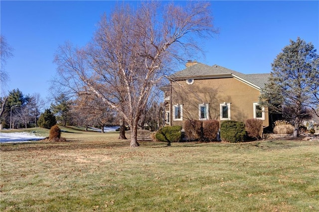 view of side of home with a yard