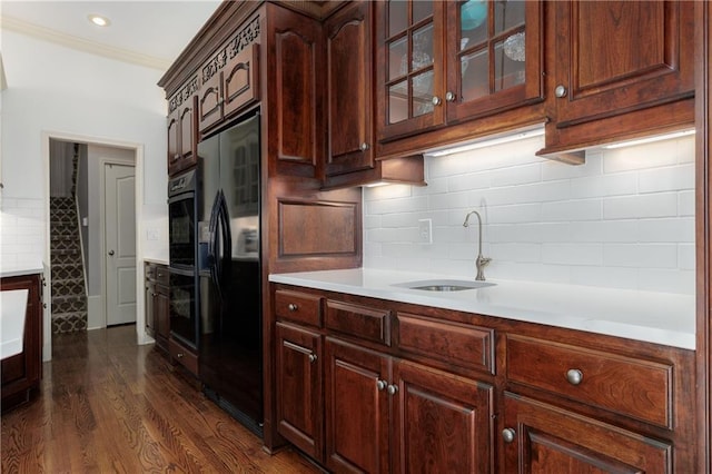 kitchen featuring sink, crown molding, dark hardwood / wood-style floors, decorative backsplash, and black appliances