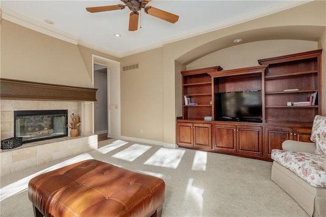 living room featuring a fireplace, ornamental molding, and ceiling fan