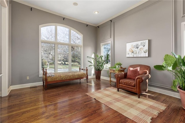 living area with ornamental molding and dark hardwood / wood-style floors