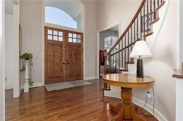 foyer featuring dark hardwood / wood-style flooring and a towering ceiling