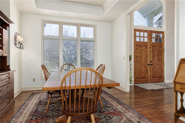 dining room featuring a tray ceiling, dark wood-type flooring, and ornamental molding