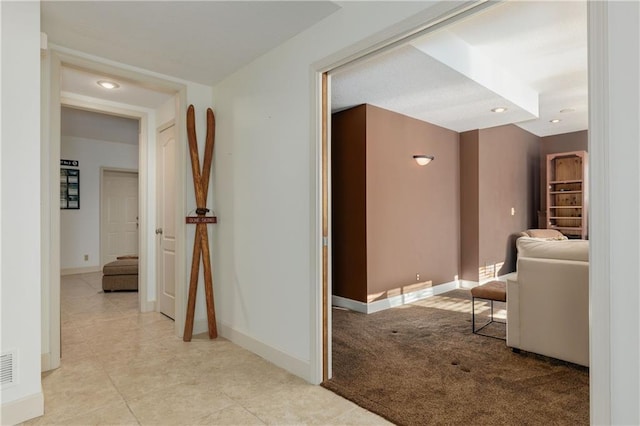 hallway featuring light colored carpet