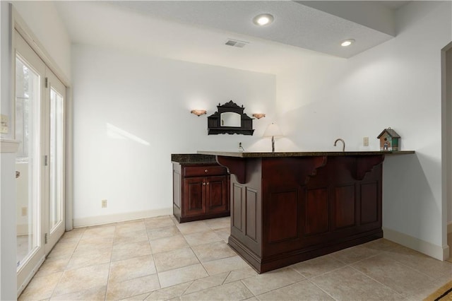 bar featuring light tile patterned floors and sink