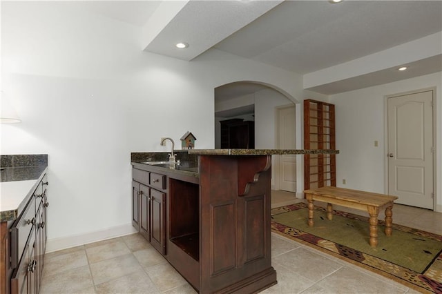 kitchen with kitchen peninsula, sink, and light tile patterned floors