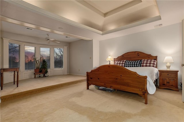 carpeted bedroom featuring ceiling fan and a tray ceiling