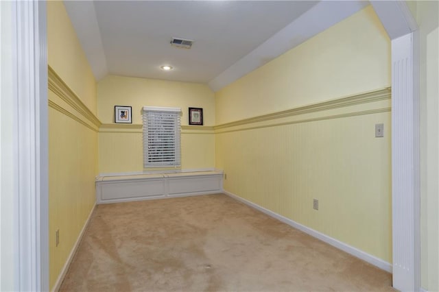 interior space with vaulted ceiling and light colored carpet