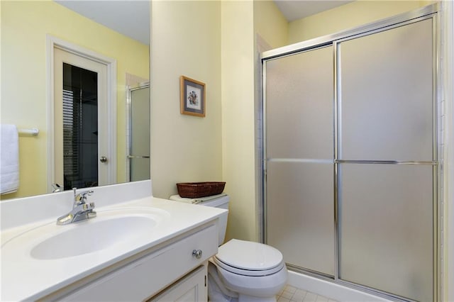 bathroom with vanity, a shower with door, and toilet