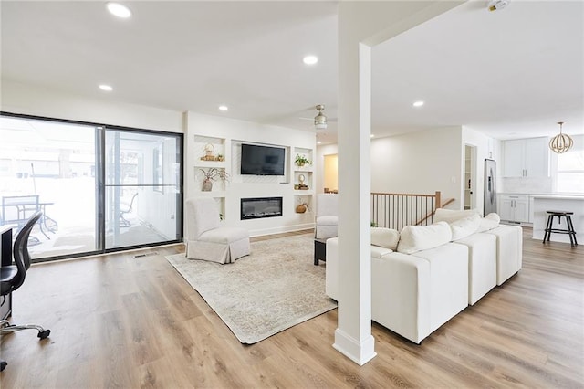 living room with ceiling fan and light wood-type flooring