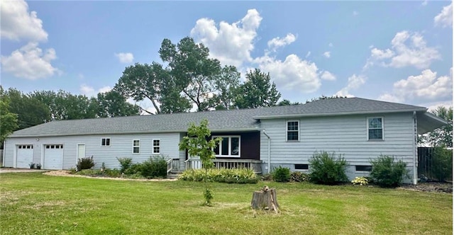 back of property with a lawn and a garage