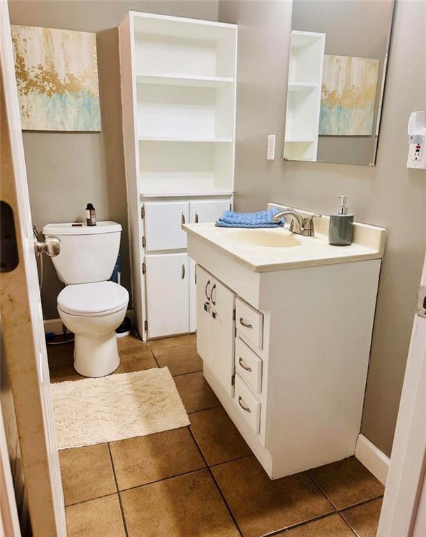 bathroom featuring tile patterned flooring, vanity, and toilet