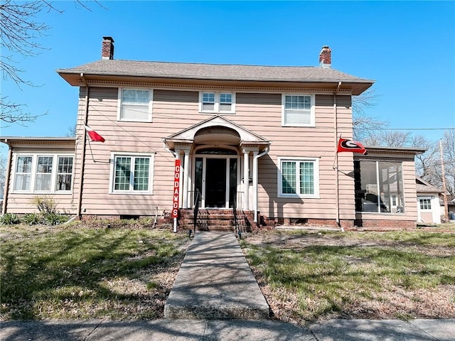 colonial inspired home featuring a front lawn