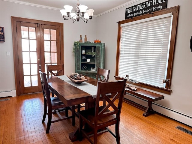 dining room with french doors, wood-type flooring, ornamental molding, and a notable chandelier