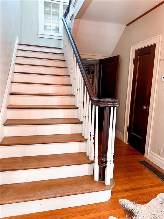 staircase with hardwood / wood-style flooring