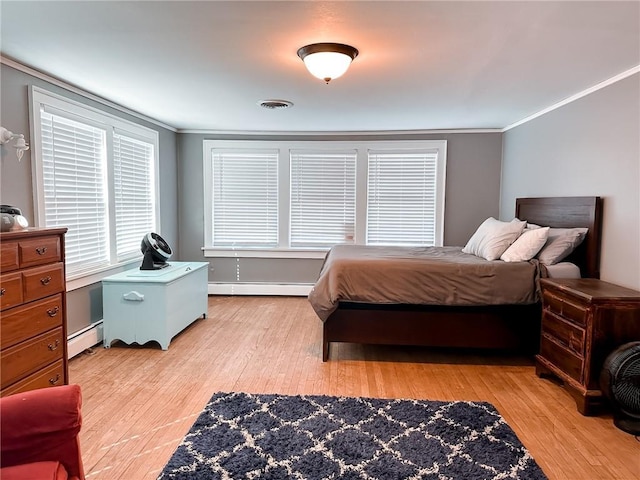 bedroom with baseboard heating, ornamental molding, and light wood-type flooring