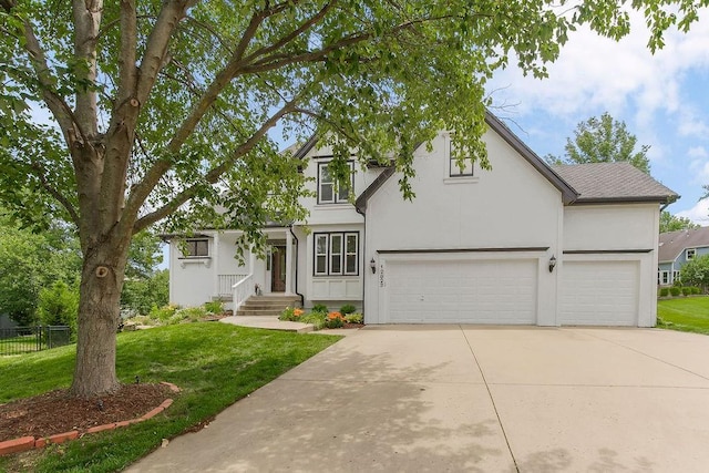 12823 Connell St, Overland Park, KS 66213 - view of front of house with driveway, stucco siding, and an attached garage