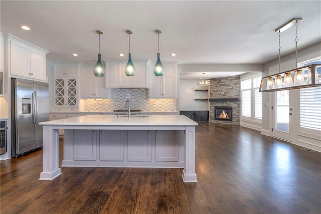 kitchen with white cabinets, dark wood-type flooring, and stainless steel refrigerator with ice dispenser