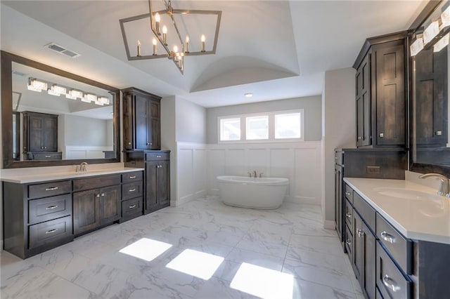 bathroom featuring a washtub, lofted ceiling, and vanity