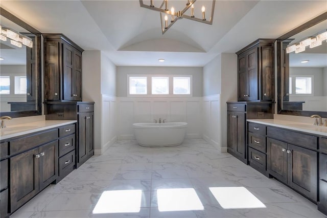 bathroom with vanity, lofted ceiling, and a bath