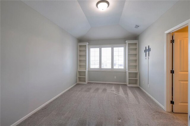 carpeted spare room featuring vaulted ceiling