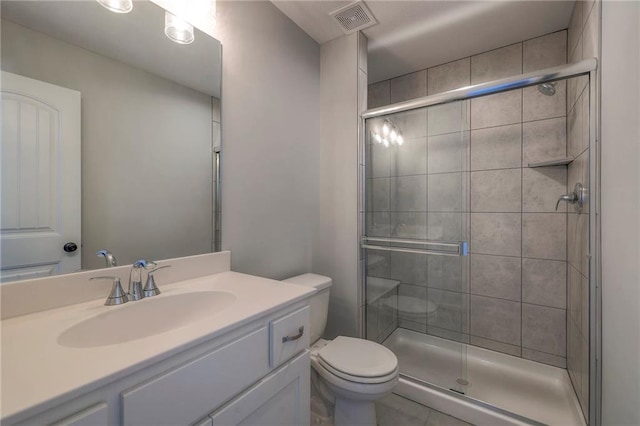 bathroom with tile patterned flooring, a shower with door, vanity, and toilet