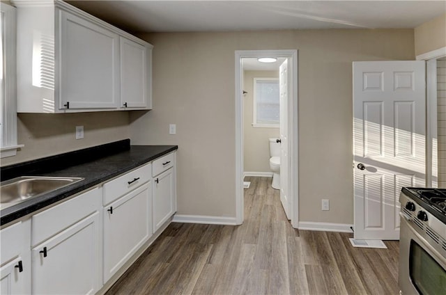 kitchen featuring white cabinetry, light hardwood / wood-style flooring, sink, and stainless steel range with gas stovetop