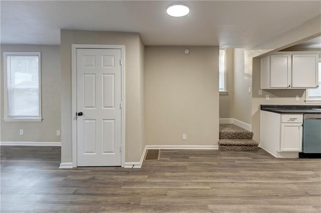 kitchen featuring dishwasher, light wood-type flooring, white cabinetry, and a wealth of natural light