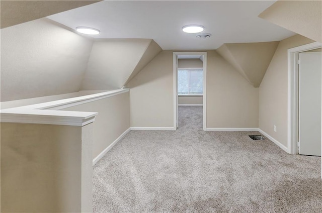 additional living space featuring light carpet and lofted ceiling