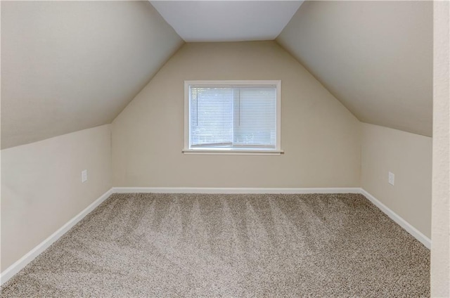 additional living space featuring carpet floors and vaulted ceiling