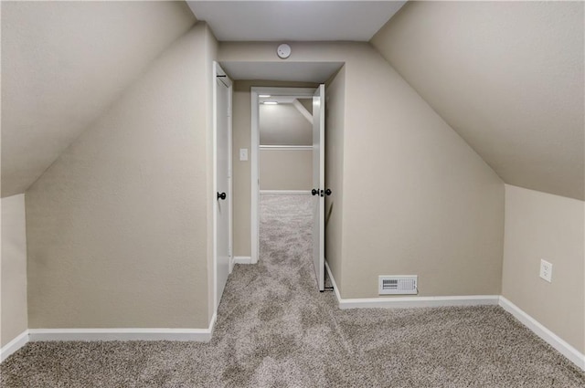 additional living space with light carpet and vaulted ceiling