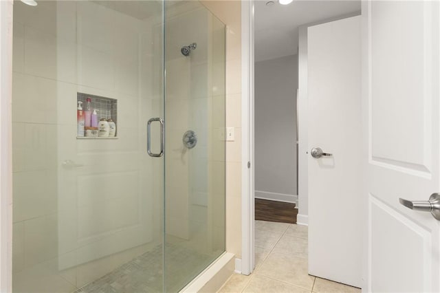 bathroom featuring tile patterned flooring and an enclosed shower