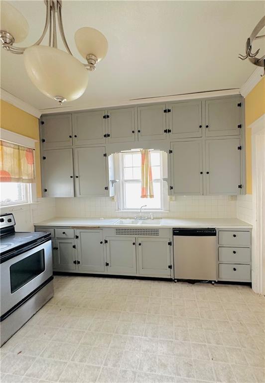 kitchen with dishwasher, stainless steel range with electric cooktop, sink, gray cabinets, and decorative light fixtures