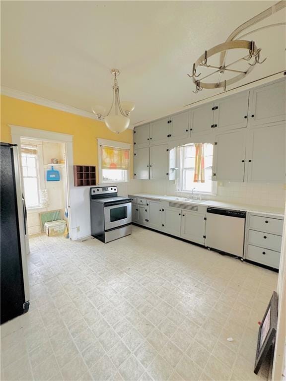 kitchen featuring pendant lighting, stainless steel electric stove, white dishwasher, refrigerator, and a wealth of natural light